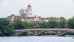Kayaking in John W. Weeks Bridge and clock tower over Charles River in Harvard University campus in Cambridge, Boston Massachusetts.