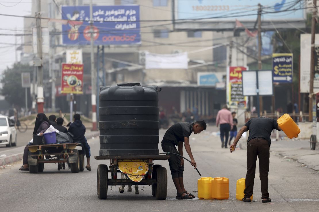 People fill plastic containers with potable water in Rafah, in the southern Gaza Strip on October 23, 2023.