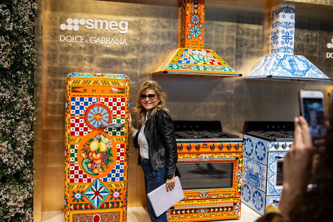 A woman poses next to a Dolce & Gabbana-designed refrigerator at the SMEG display stand during the Milan Furniture Fair on April 17, 2018.