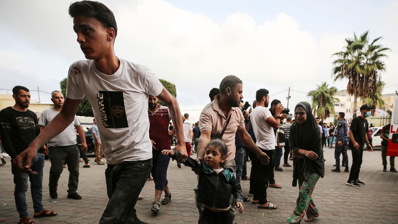 People gather as medics transport injured people into Al-Aqsa Martyrs Hospital in Deir al-Balah in Gaza, following an Israeli strike on October 22, 2023.