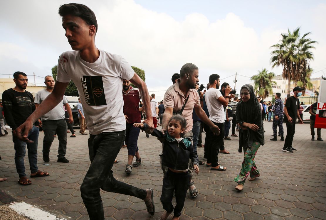 People gather as medics transport injured people into Al-Aqsa Martyrs Hospital in Deir al-Balah in Gaza, following an Israeli strike on October 22.