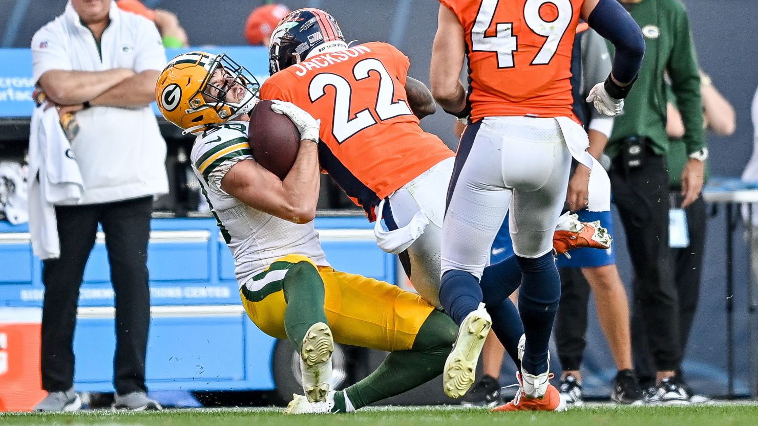 DENVER, COLORADO - OCTOBER 22:  Tight end Luke Musgrave #88 of the Green Bay Packers is hit by safety Kareem Jackson #22 of the Denver Broncos after a reception in the fourth quarter that would result in an ejection of Jackson at Empower Field at Mile High on October 22, 2023 in Denver, Colorado. (Photo by Dustin Bradford/Getty Images)