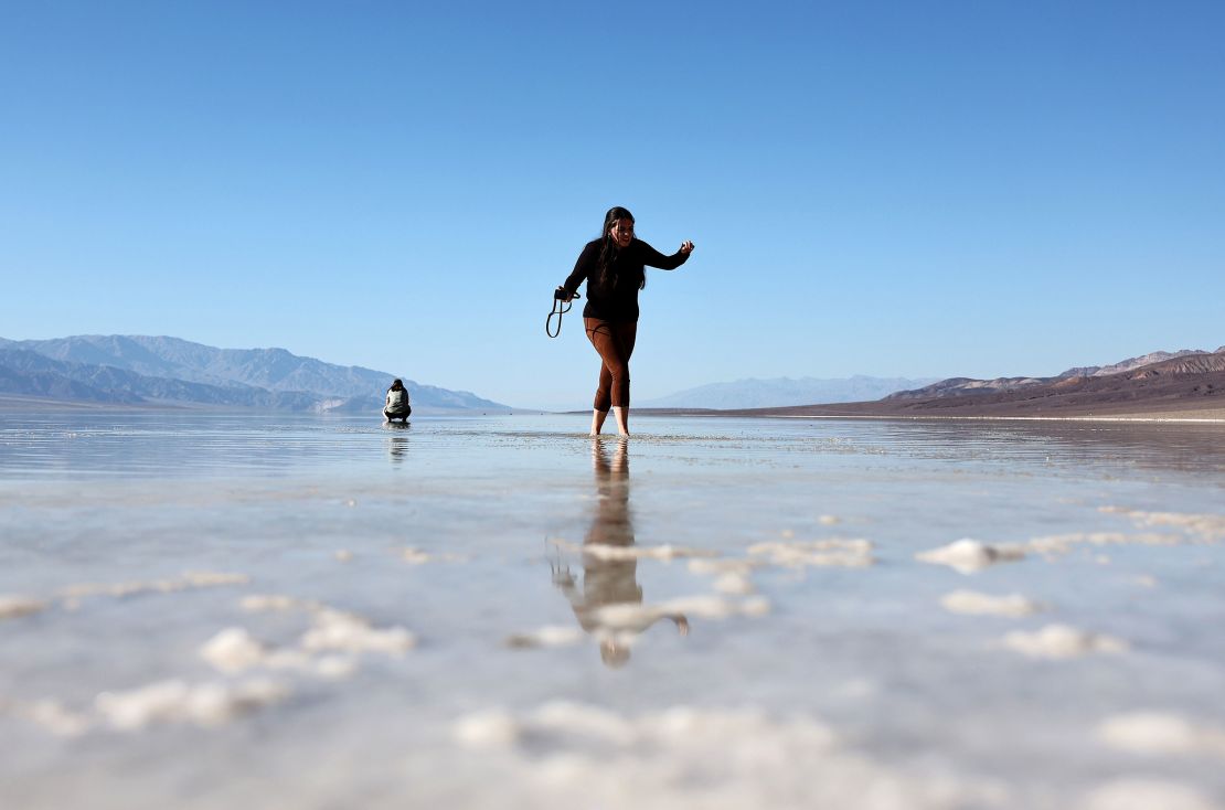 Посетител разходки в обширното краткотрайно езеро в солниците Badwater Basin в националния парк Death Valley на 21 октомври 2023 г.