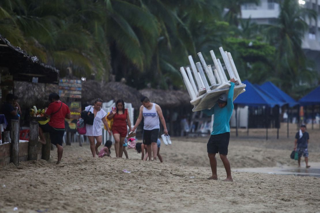 A man removes tables off a beach as Hurricane Otis barrels towards Acapulco, Mexico, on October 24, 2023. 