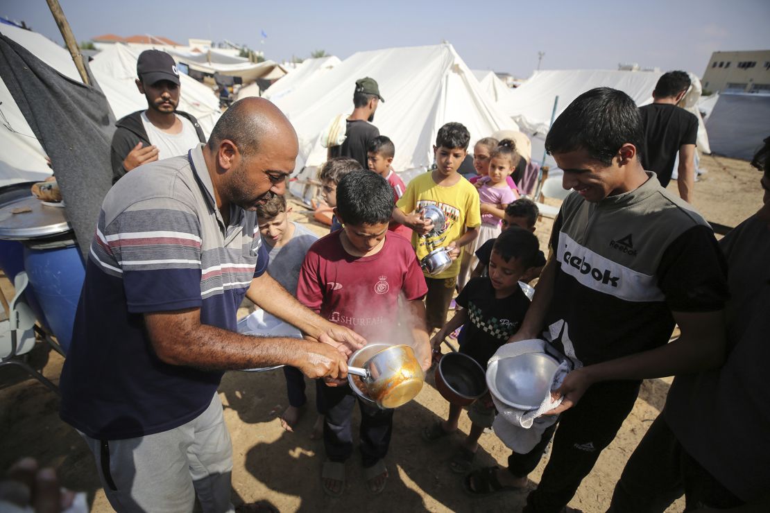 Palestinian children receive food from a United Nations Relief and Works Agency for Palestine Refugees (UNRWA) centre in Gaza on Tuesday.