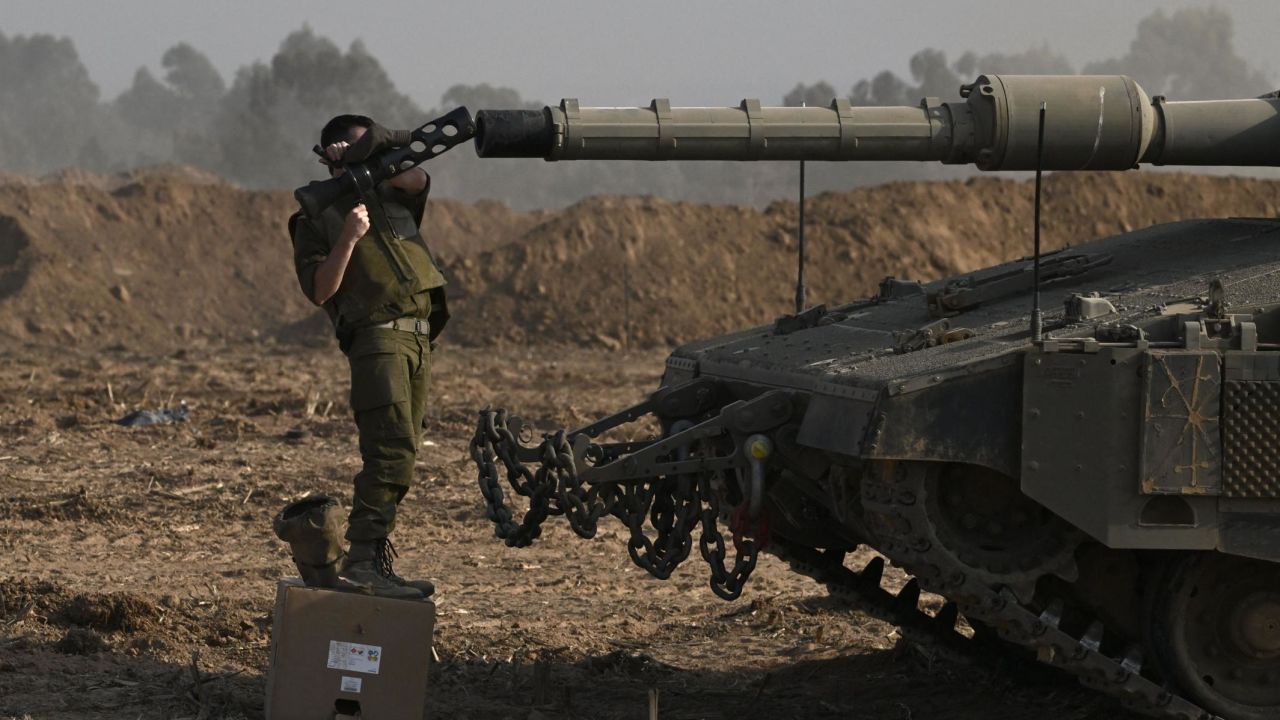 An Israeli solider checks the gun of a Merkava tank deployed along Israel's border with Gaza on October 24, 2023, amid the ongoing battles between Israel and the Palestinian group Hamas. Thousands of civilians, both Palestinians and Israelis, have died since October 7, 2023, after Palestinian Hamas militants based in the Gaza Strip entered southern Israel in an unprecedented attack triggering a war declared by Israel on Hamas with retaliatory bombings on Gaza. (Photo by Aris MESSINIS / AFP) (Photo by ARIS MESSINIS/AFP via Getty Images)