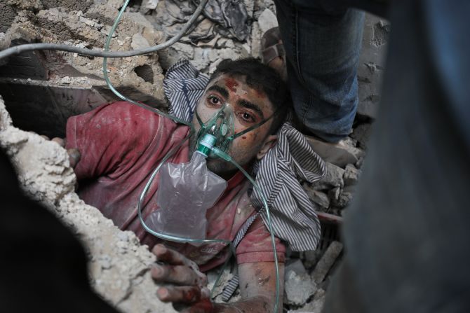 Rescuers assist a survivor of an Israeli bombardment in Nusseirat refugee camp, Gaza on October 24.