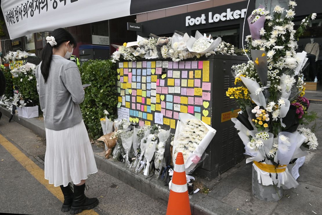 A woman looks at messages of mourners at a makeshift memorial for the victims of the deadly Halloween crowd surge, outside a subway station in the district of Itaewon in Seoul on November 3, 2022. (Photo by Jung Yeon-je / AFP) (Photo by JUNG YEON-JE/AFP via Getty Images)