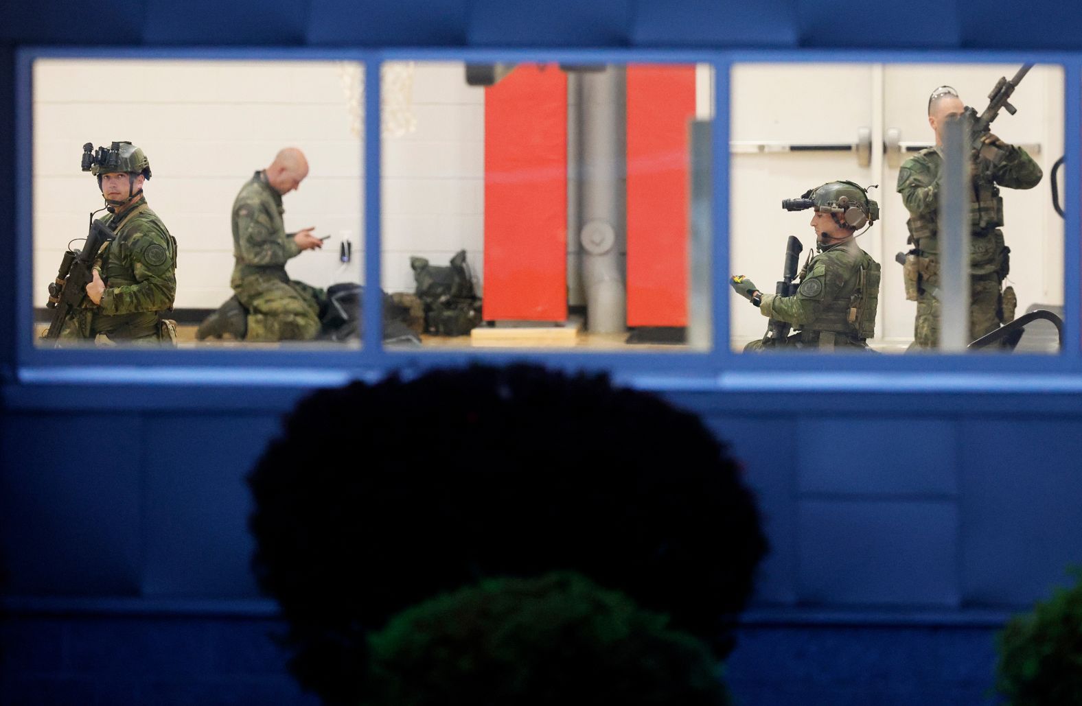 Law enforcement officials prepare at Lisbon High School at daybreak on Thursday, as a manhunt resumes for the suspect in the mass shootings in Lewiston, Maine.