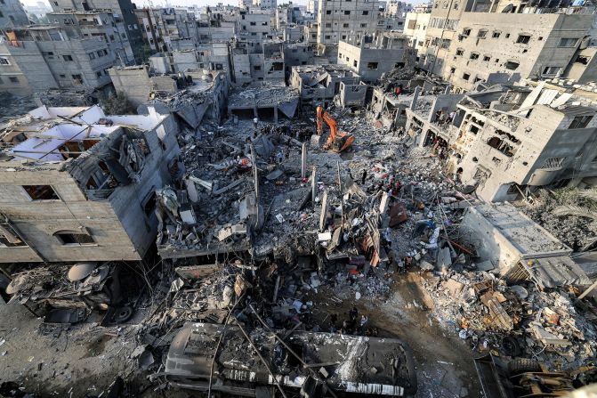 An excavator clears rubble as people search for survivors and the bodies of victims after an Israeli bombardment, in Khan Younis, southern Gaza, on October 25.
