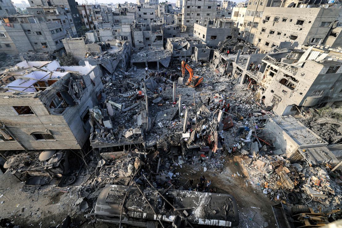TOPSHOT - An excavator clears rubble as people search for survivors and the bodies of victims through buildings that were destroyed during Israeli bombardment, in Khan Younis in the southern Gaza Strip on October 25, 2023, amid the ongoing battles between Israel and the Palestinian group Hamas. (Photo by Mahmud HAMS / AFP) (Photo by MAHMUD HAMS/AFP via Getty Images)