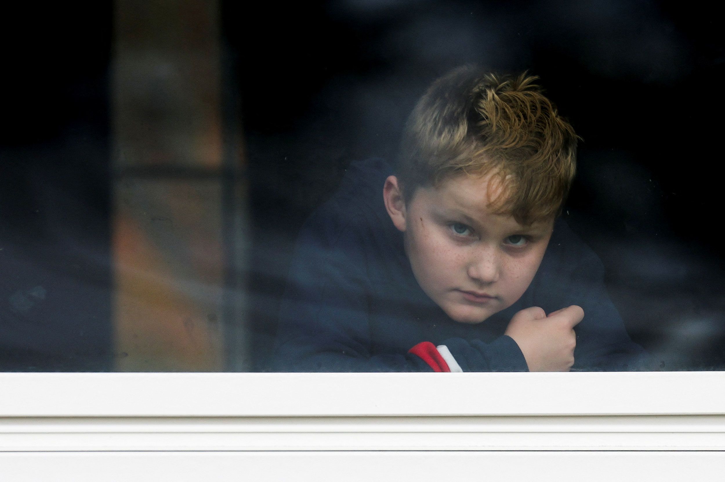 Dexter Britton, 9, looks out through a window in Lisbon Falls, Maine, on Thursday.