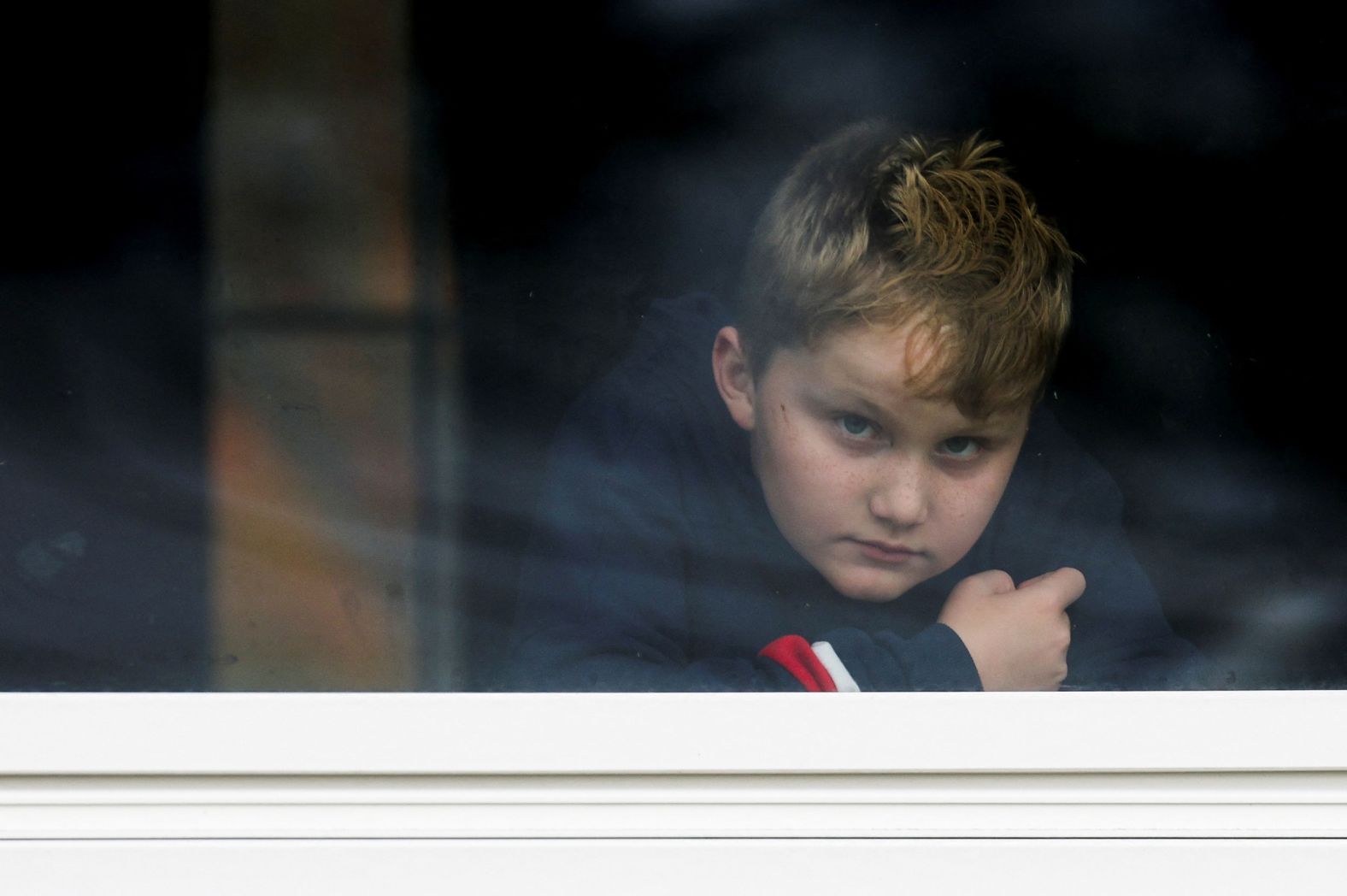 Dexter Britton, 9, looks out through a window in Lisbon Falls, Maine, on Thursday. The Lisbon area has been under a shelter in place order since Wednesday night.