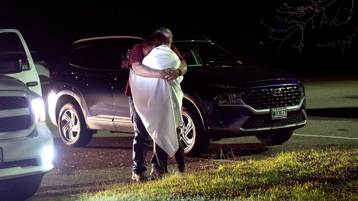 A woman is hugged by a man at a reunification center at Auburn Middle School, in Auburn, Maine, after shootings in Lewiston on Wednesday, October 25, 2023.