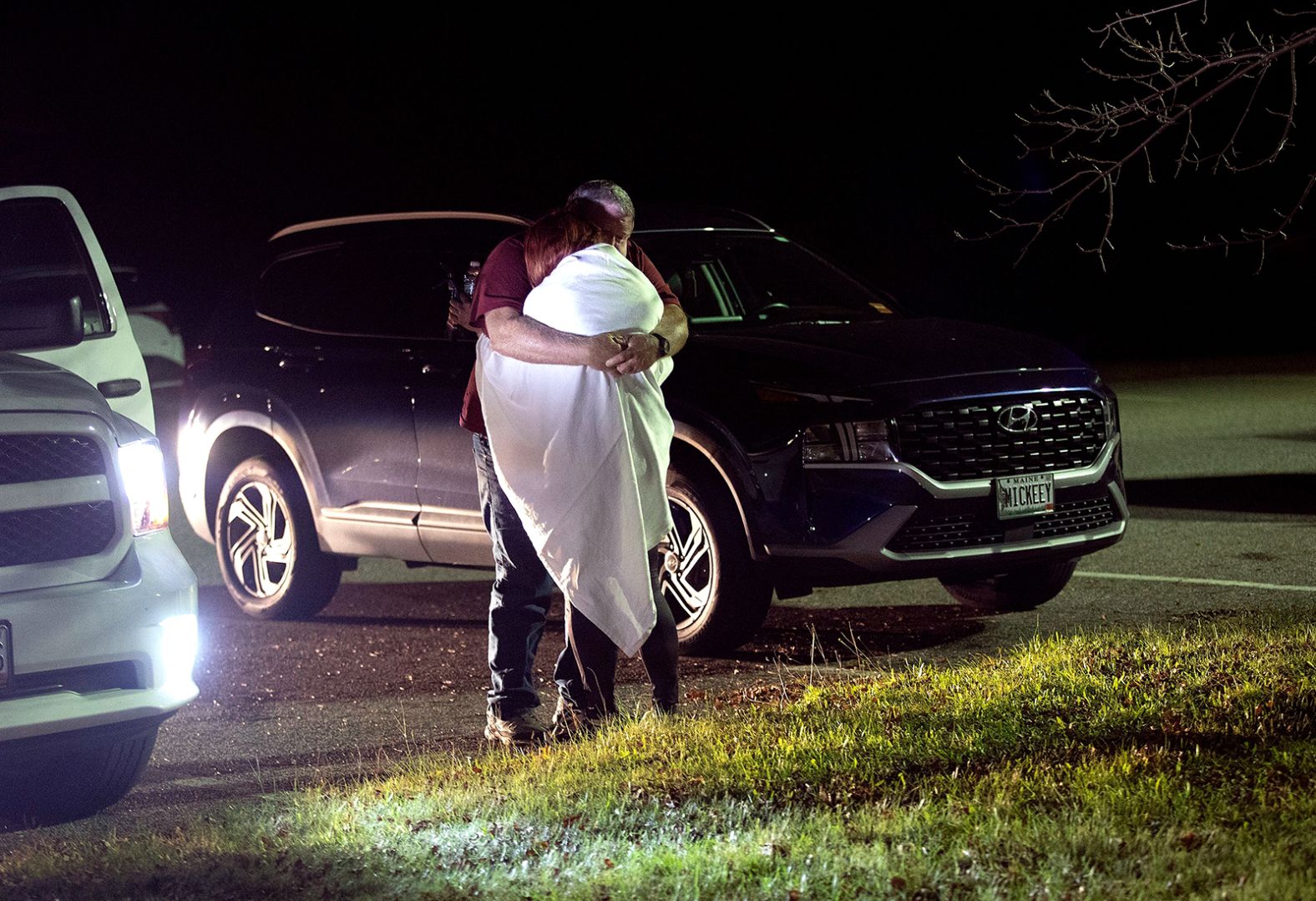 A man and woman embrace at the reunification center at Auburn Middle School in Auburn, Maine, after the mass shootings in Lewiston on Wednesday, October 25.