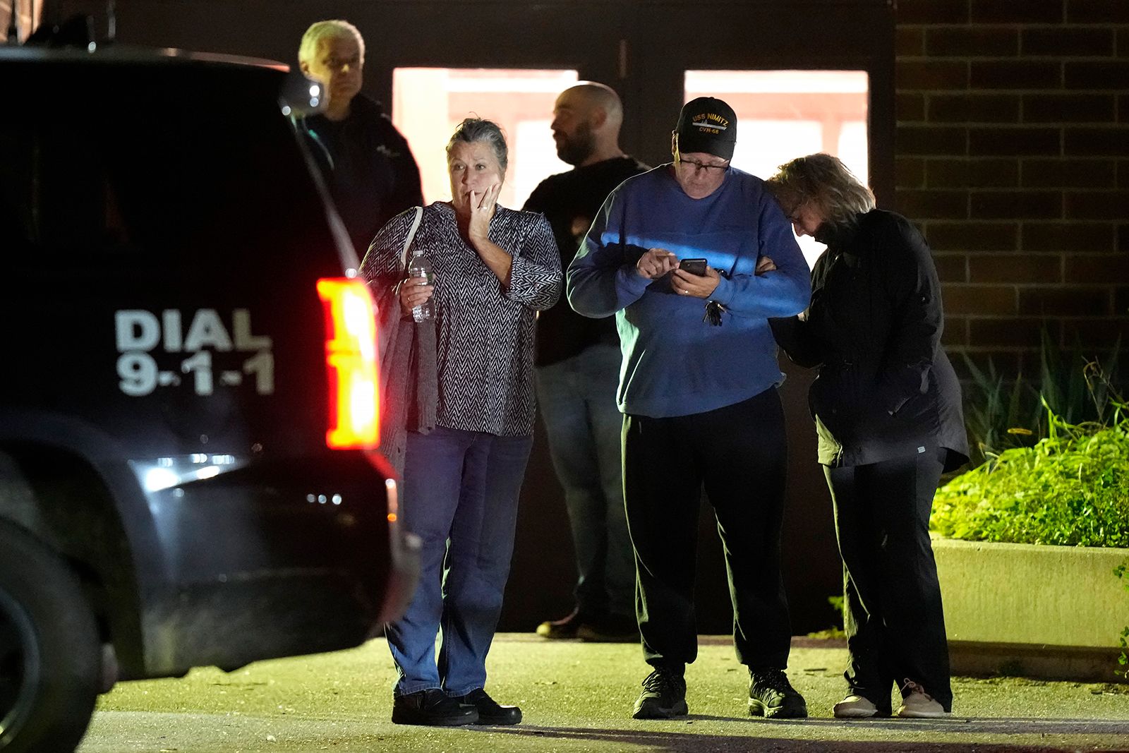 People stand outside the reunification center at Auburn Middle School.