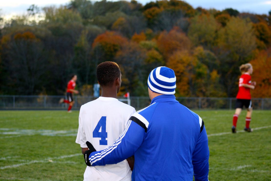 Dan Gish wraps his arm around a player at a quarterfinal game in 2016.