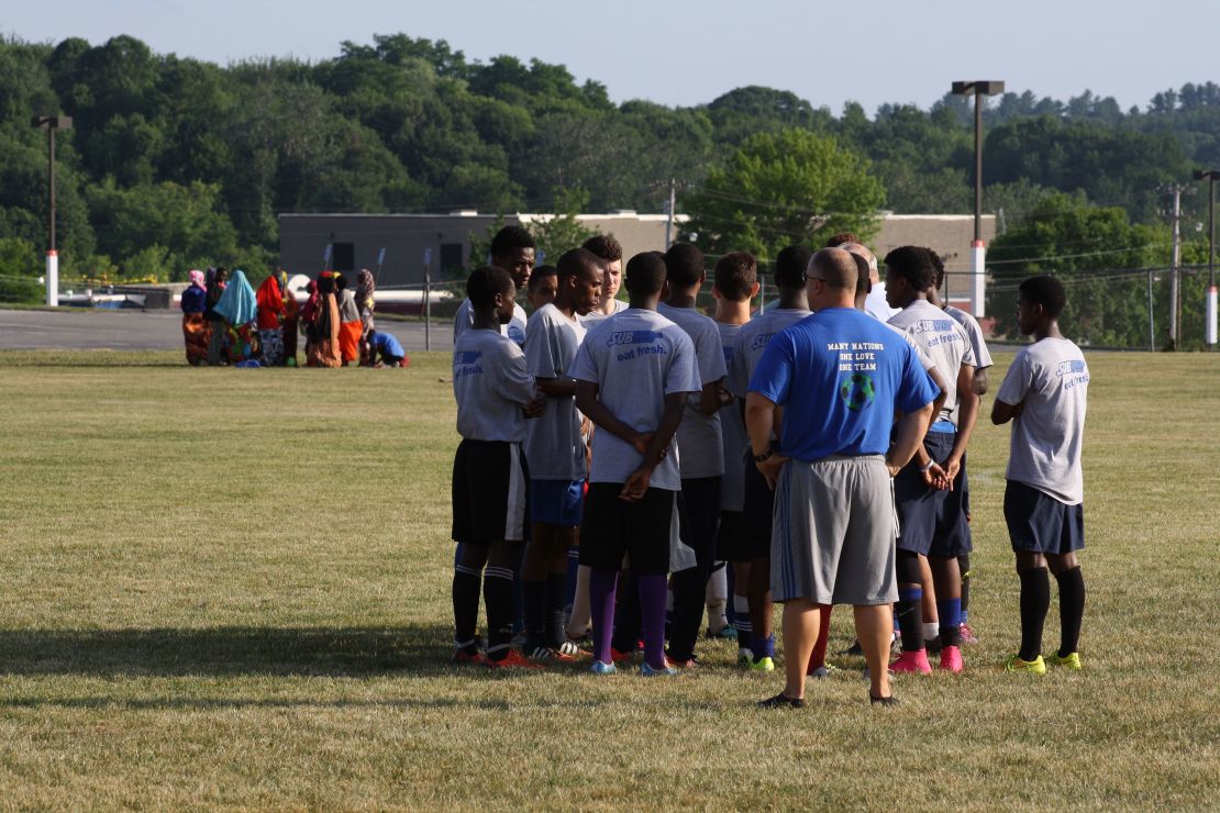 Dan Gish oversees a huddle while players' mothers and sisters huddle in the background in 2016