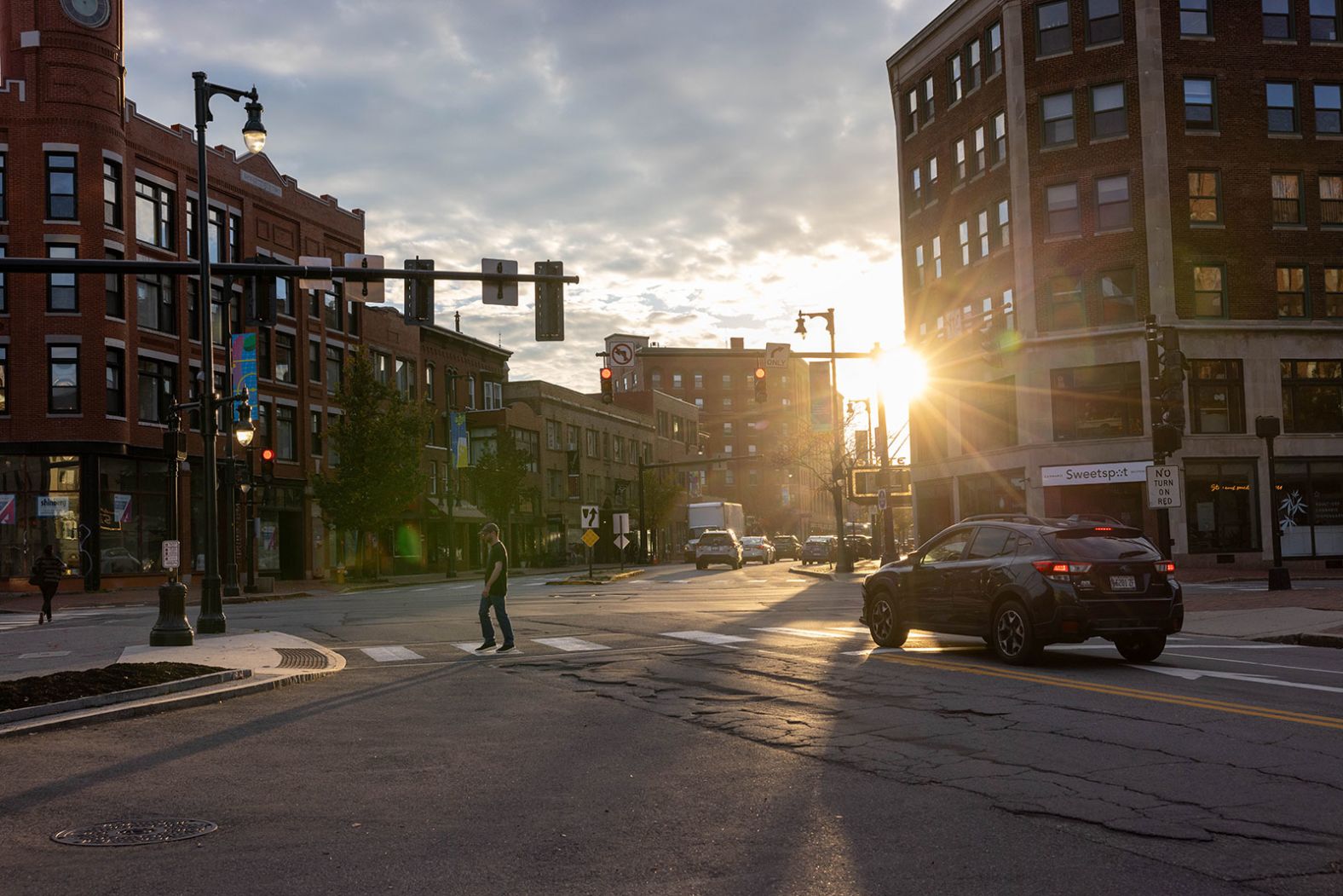 A pedestrian crosses a virtually empty street in Portland, Maine, on Thursday. The shootings took place about 36 miles north of the city.