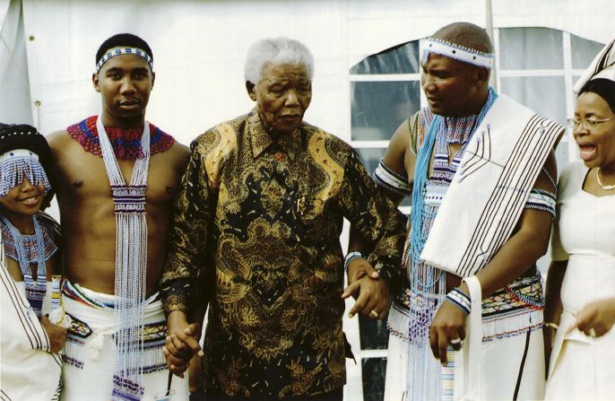 Mandela in his later years attends a traditional wedding alongside grandsons Ndaba and Mandla and wife Graça in Qunu, his childhood village. "My father had fond memories of Qunu," said Dr. Mandela. "It's where his parents and sister Libby are buried. His wish was to be buried in Qunu and wanted to take his last breath there, which unfortunately did not happen. (He) always stressed the importance of keeping it in the family as a special place where we could all congregate. Ultimately, the goal is to turn it into a memorial and spiritual garden, a place where people can visit and reflect."