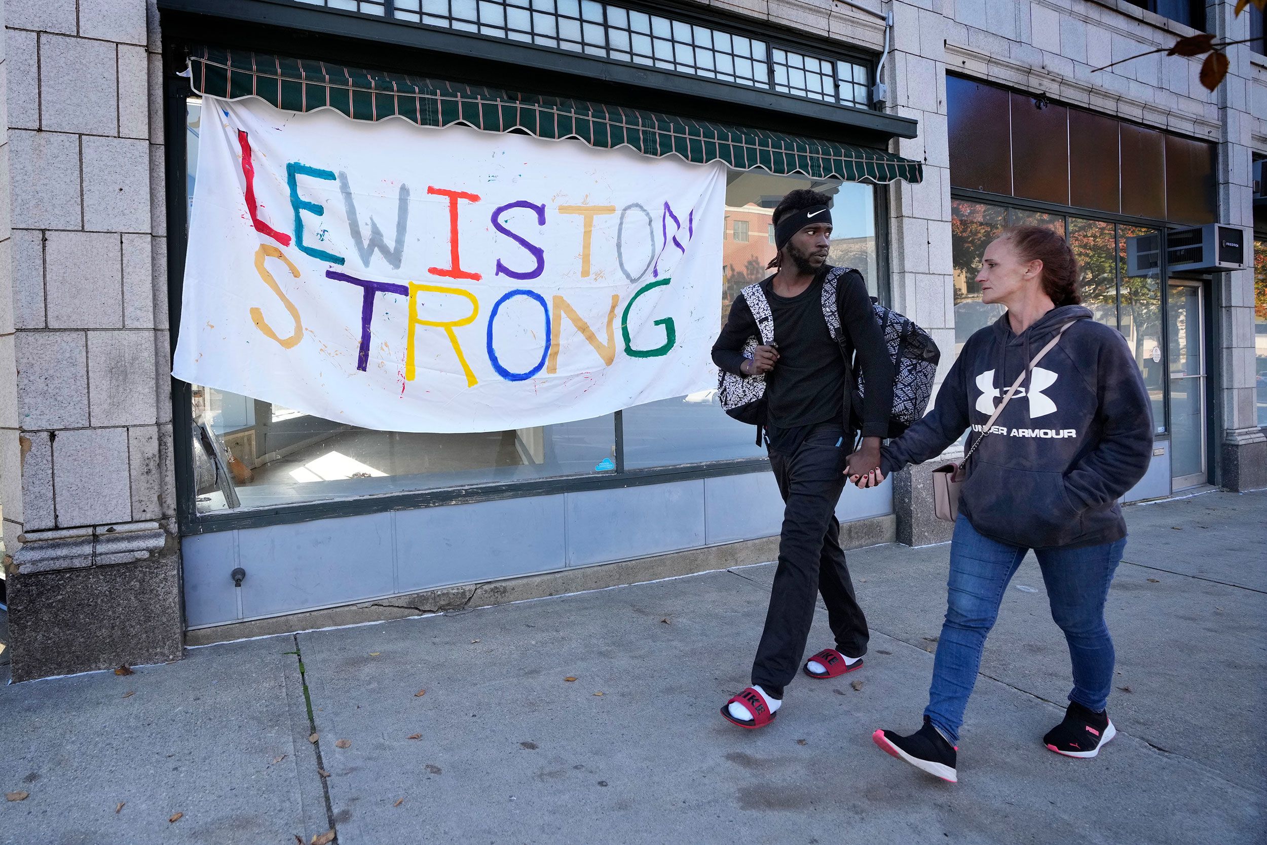 A couple walks by a banner in Lewiston on Friday.