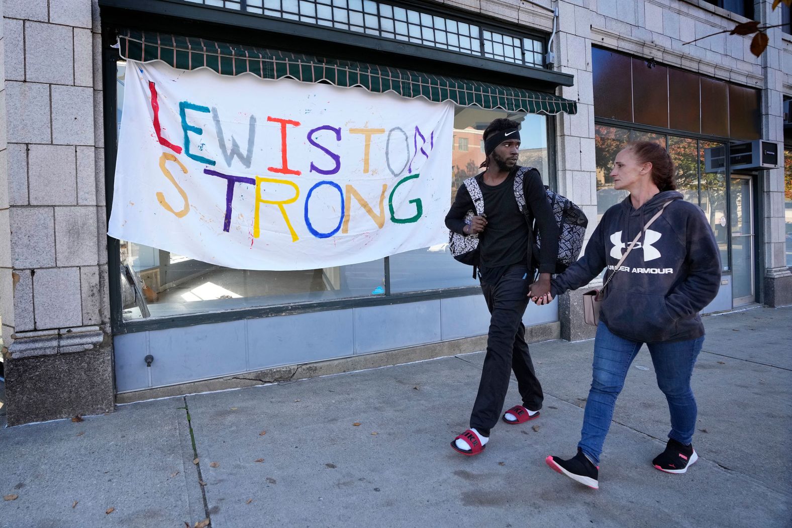 A couple walks by a banner in Lewiston on Friday. 