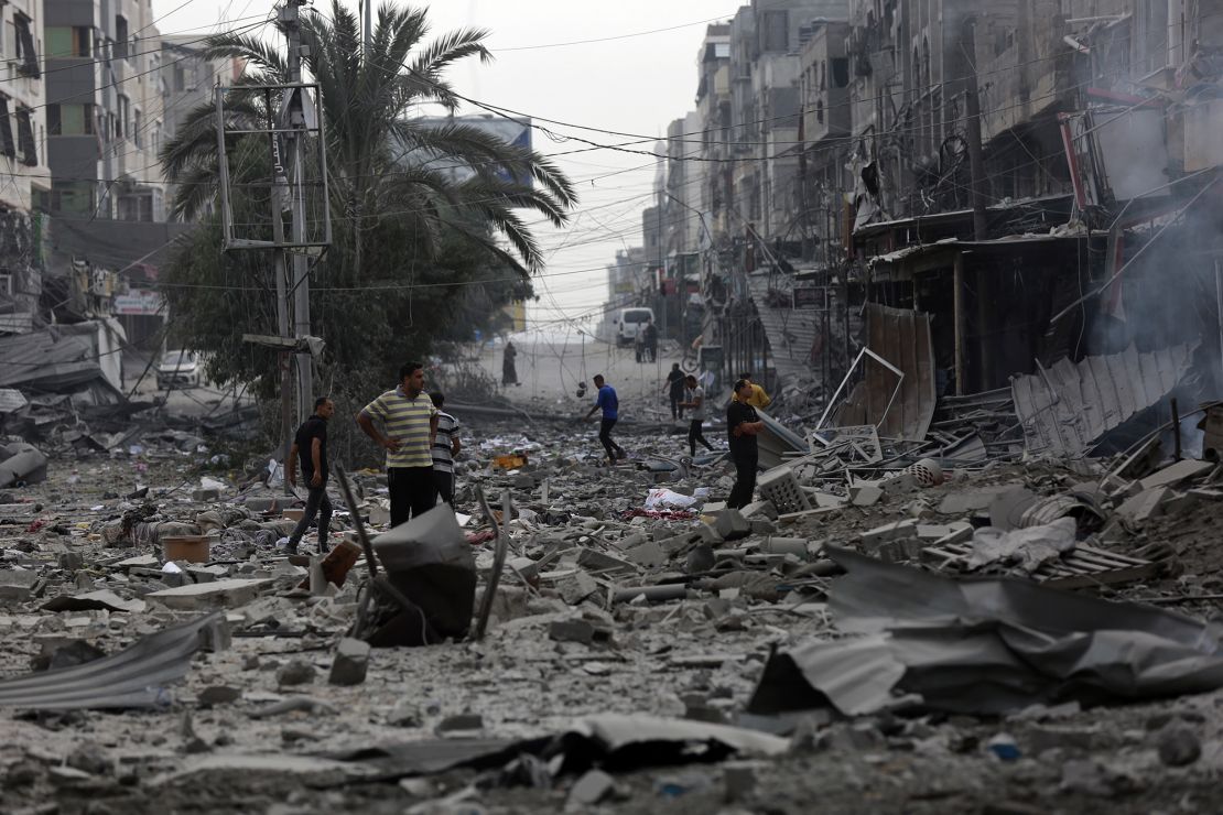 Palestinians inspect the damage of destroyed buildings following Israeli airstrikes on Gaza City on Friday.