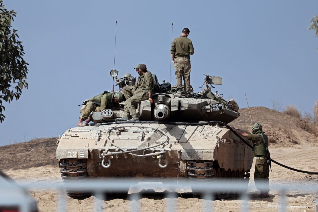 TOPSHOT - Israeli soldiers refuel their Merkava tank near the southern Israeli city of Sderot on October 23, 2023, amid the ongoing battles between Israel and the Palestinian group Hamas. Thousands of people, both Israeli and Palestinians have died since October 7, 2023, after Palestinian Hamas militants based in the Gaza Strip, entered southern Israel in a surprise attack leading Israel to declare war on Hamas in Gaza on October 8. (Photo by Thomas COEX / AFP) (Photo by THOMAS COEX/AFP via Getty Images)