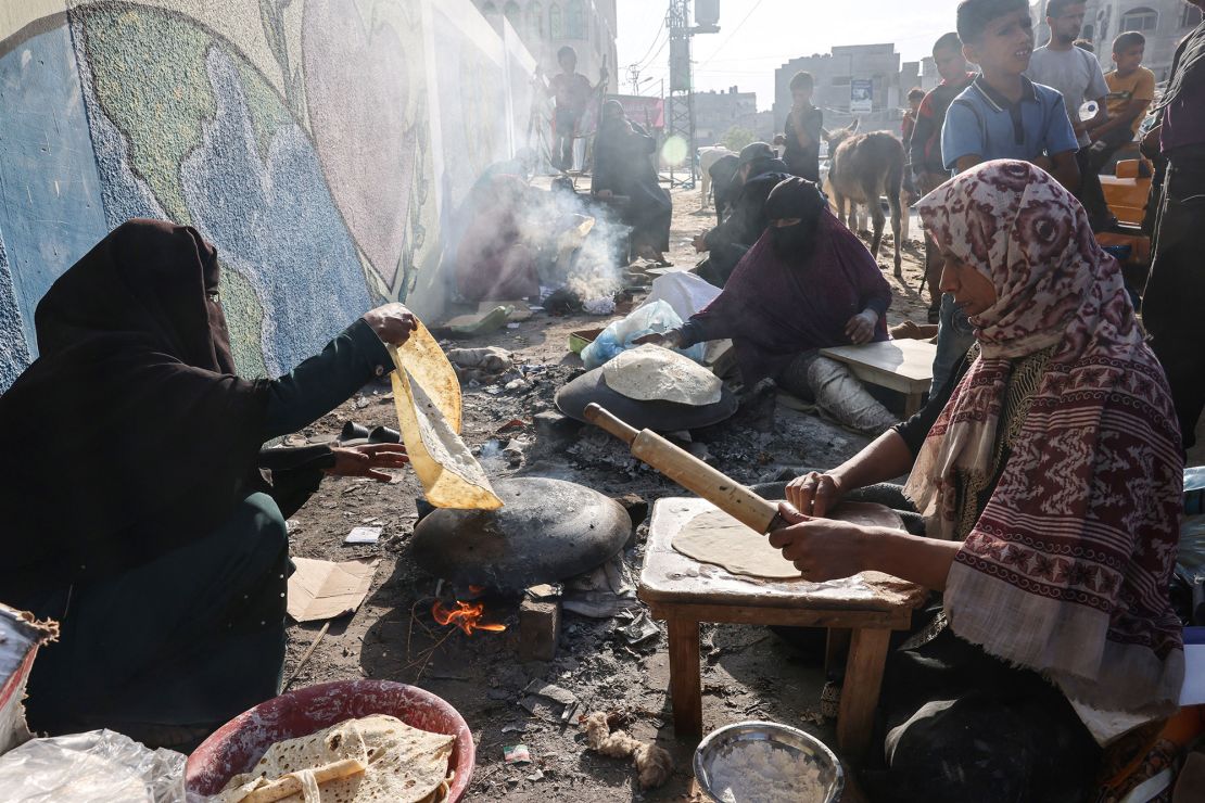 Palestinian women use an open fire to cook at a shelter for displaced families, mainly from the northern Gaza Strip, at a UN-run school in Rafah, southern Gaza Strip, October 27, 2023, amid ongoing fighting between Israel and Israel Traditional unleavened bread. and the Palestinian Hamas movement.  (Photo by SAID KHATIB/AFP) (Photo by SAID KHATIB/AFP via Getty Images)
