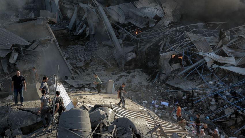 People walk through rubble following an Israeli strike on Gaza, on October 26, 2023.