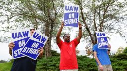 Members of the United Auto Workers (UAW) union hold signs outside after walking out from the General Motors parts distribution center in Bolingbrook, Illinois, on September 22, 2023. The US auto workers union expanded a potentially economically and politically damaging strike against two of Detroit's "Big Three" on September 22, 2023 -- and invited President Joe Biden to support workers on the picket line. UAW President Shawn Fain announced a strike of all 38 US parts and distribution centers at General Motors and Stellantis, where negotiations are stalled. (Photo by KAMIL KRZACZYNSKI / AFP) (Photo by KAMIL KRZACZYNSKI/AFP via Getty Images)