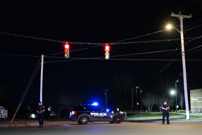 Police officers guard the road to a recycling facility where the body of Robert Card, the suspect in this week's mass shootings, was found, on Friday, October 27, in Lisbon, Maine.