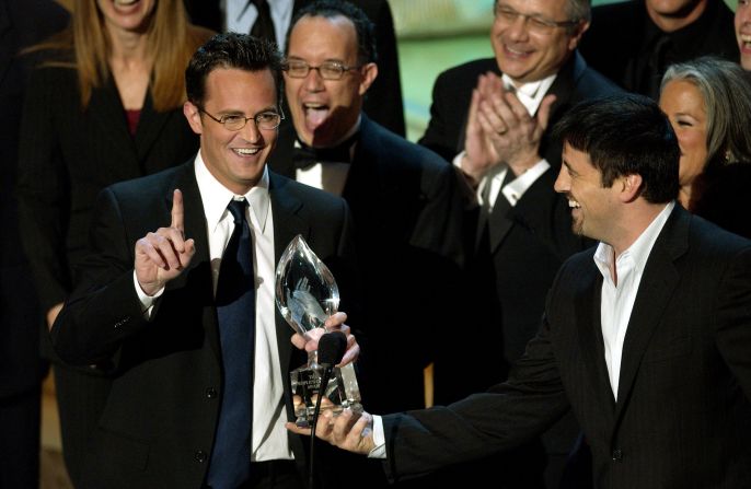 Perry prepares to make a statement as fellow "Friends" cast member  LeBlanc hands over the award they won for favorite television comedy series at the 2004 People's Choice Awards.