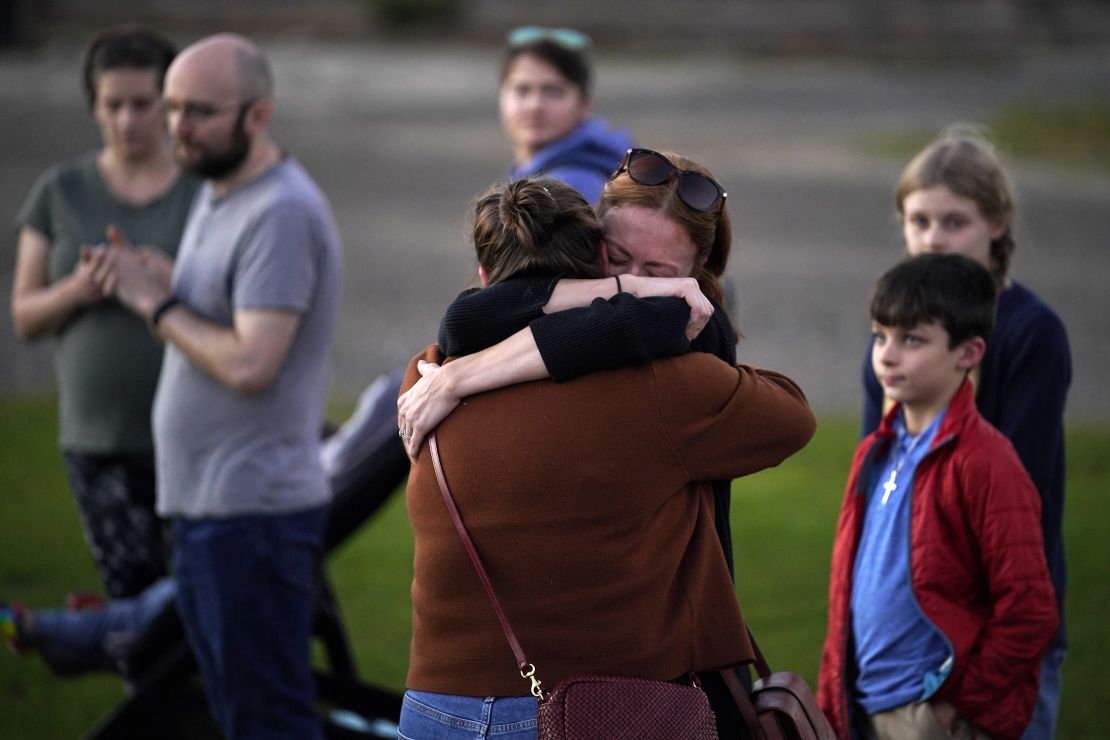 Lindsay Marlow, facing camera, hugs Courtney Majoros, at a vigil in Lisbon Falls, Maine, for the victims of this week's mass shootings, Saturday, Oct. 28, 2023. Courtney Majoros' brother, Max Hathaway, was one of the people killed in separate shootings in nearby Lewiston, Maine, on Wednesday. (AP Photo/Robert F. Bukaty)