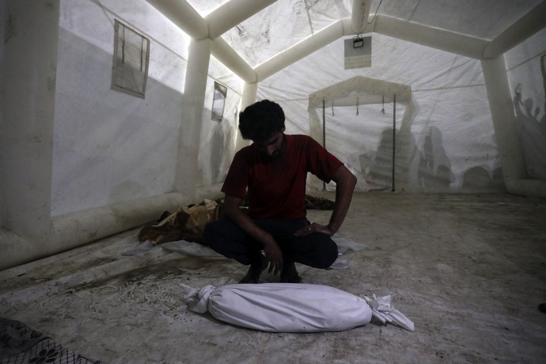 A Palestinian man mourns next to the body of his child who was killed in Israeli airstrikes on Gaza Strip, at the al Shifa hospital in Gaza City, Tuesday, Oct. 24, 2023. (AP Photo/Abed Khaled)