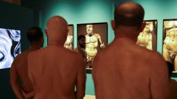 SENSITIVE MATERIAL. THIS IMAGE MAY OFFEND OR DISTURB Guide Edgard Mestre talks to residents as they take part in a nudist visit to the Archaeology Museum of Catalonia.