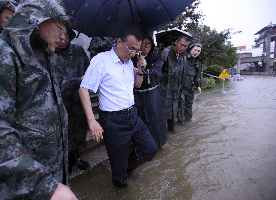 This picture taken on July 6, 2016 shows Chinese Premier Li Keqiang visiting Wuhan's Yangtze River embankment to inspect flood control and relief work in Wuhan, central China's Hubei province. Heavy rain around China's Yangtze river basin has so far left 128 people dead and scores missing, media said on July 5, with more damage feared from a typhoon expected to land this week. (Photo by AFP) / China OUT (Photo by STR/AFP via Getty Images)