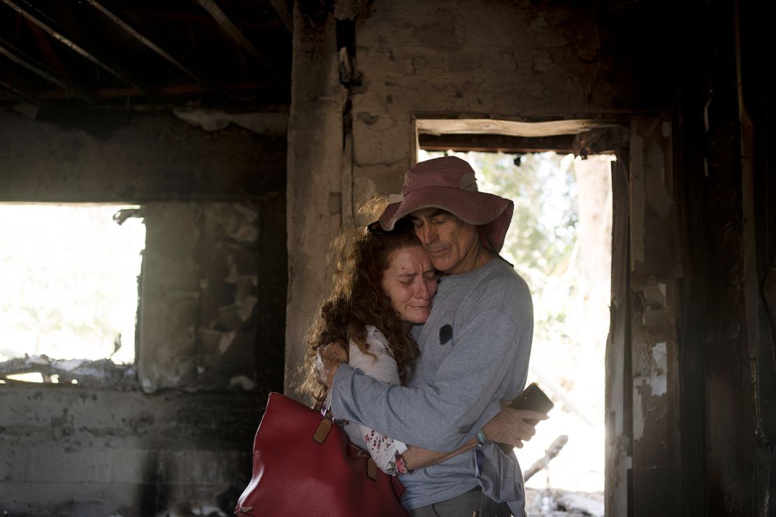 Residents of Kibbutz Nir Oz, in southern Israel, mourn inside the ruins of a home attacked by Hamas on October 30, 2023.