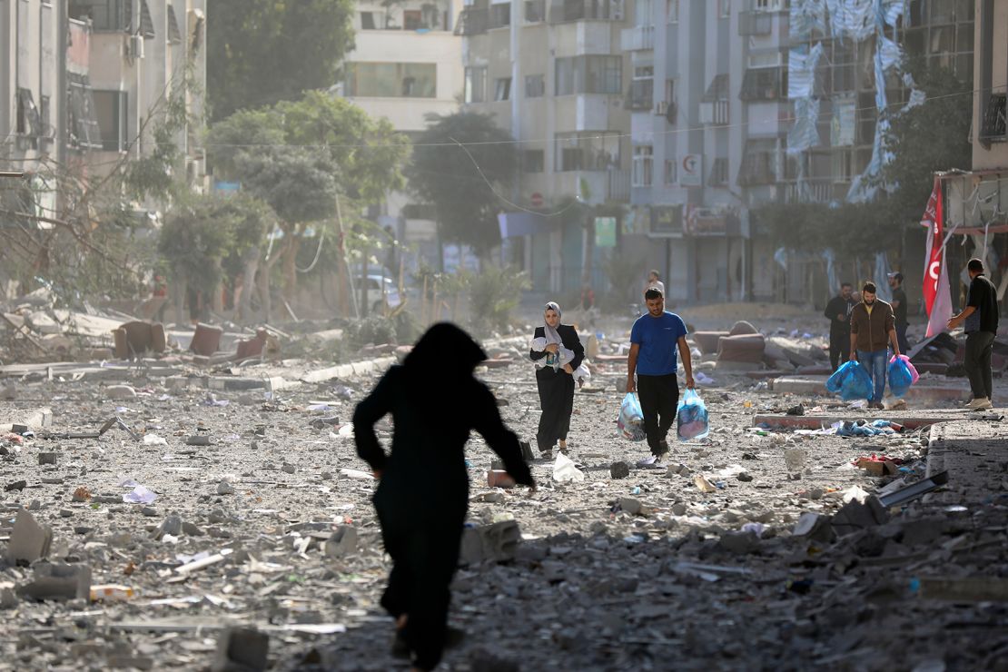 Palestinians leave their homes following Israeli bombardments on Gaza, on October 30, 2023.