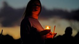 A mourner attends a candlelight vigil for the victims of this week's mass shootings on October 28, 2023, in Lisbon Falls, Maine.