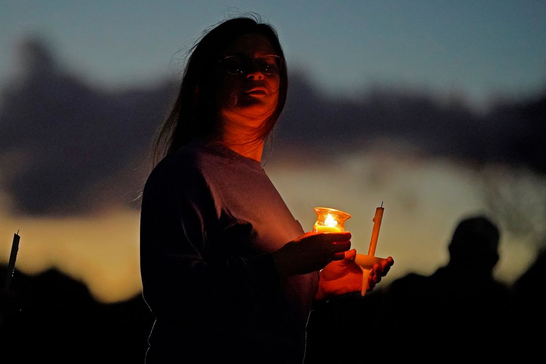 A mourner attends a weekend candlelight vigil for the victims of the mass shootings in Lisbon Falls, Maine.