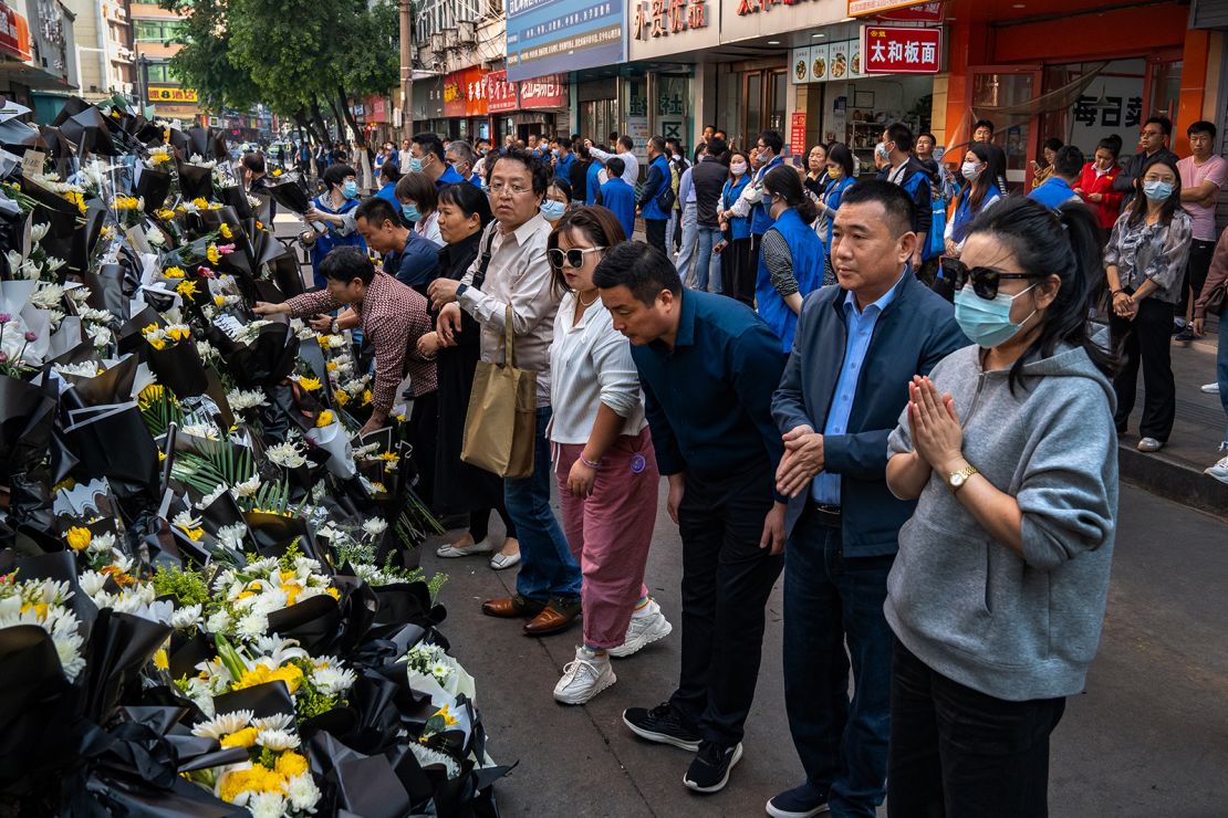 Mourners pay tribute to former Premier Li Keqiang outside his childhood residence under the watch of government workers.