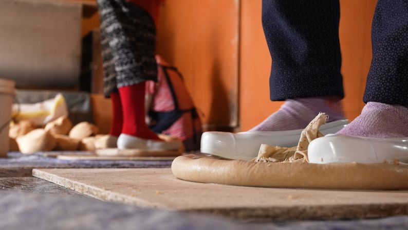 <strong>Making nuruk: </strong>The dough, wrapped in a cloth, is stomped on until round in shape, with thick edges. Geumjeongsanseong is the only makgeolli maker that still produces nuruk this way.