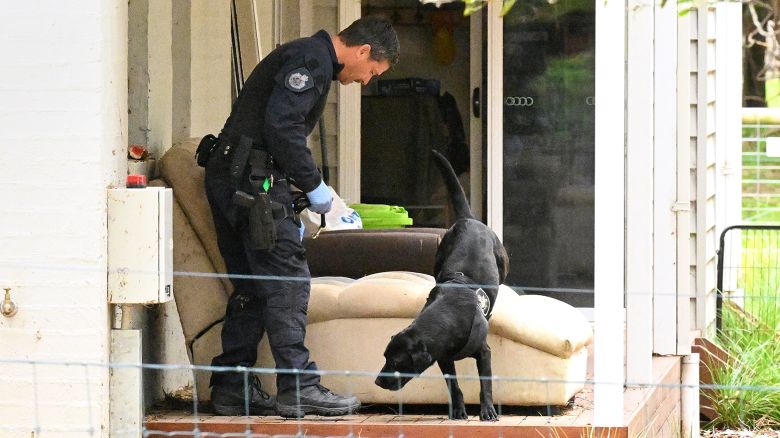 A police officer and dog investigate at the property of Erin Patterson in Leongatha, Australia, Thursday, Nov. 2, 2023. Australian police have on Thursday arrested Patterson in an investigation of a suspected mushroom poisoning incident that left three people dead.
