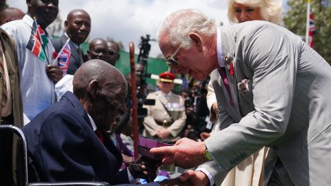 NAIROBI, KENYA - NOVEMBER 1: King Charles III and Queen Camilla meet veteran Samwel Nthigai Mburia, who is believed to be 117 years old, during a visit to the Commonwealth War Graves Commission cemetery in Nairobi, joining British and Kenyan military personnel in an act of remembrance, on day two of the state visit to Kenya on November 1, 2023 in Nairobi, Kenya. King Charles III and Queen Camilla are visiting Kenya for four days at the invitation of Kenyan President William Ruto, to celebrate the relationship between the two countries. The visit comes as Kenya prepares to commemorate 60 years of independence. (Photo by Pool - Victoria Jones/Getty Images)