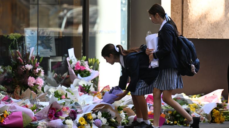 Students of St Andrew's Cathedral School lay flowers outside the school entrance on October 30, 2023.