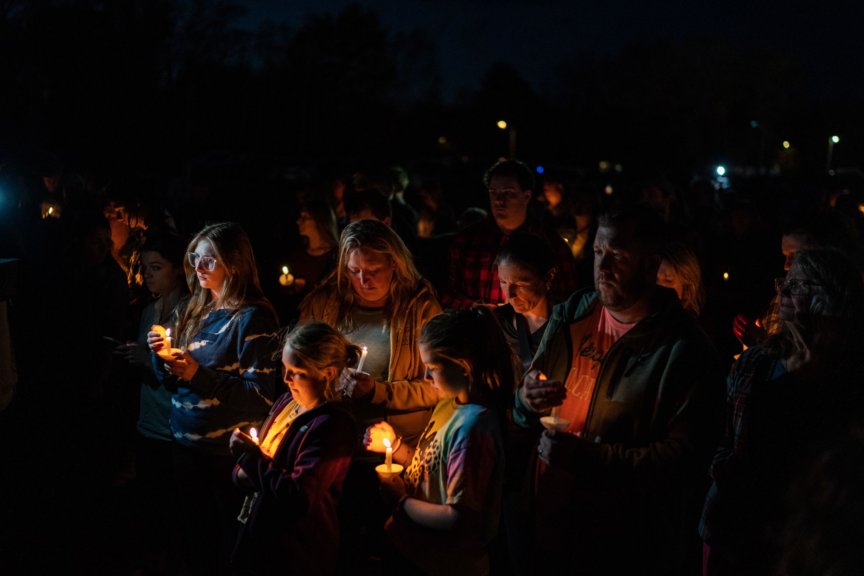 People hold a vigil for the victims of two mass shootings in Lewiston, Maine, in the neighboring city of Lisbon on Saturday, October 28. The body of the gunman was recovered Friday after a 48-hour manhunt.