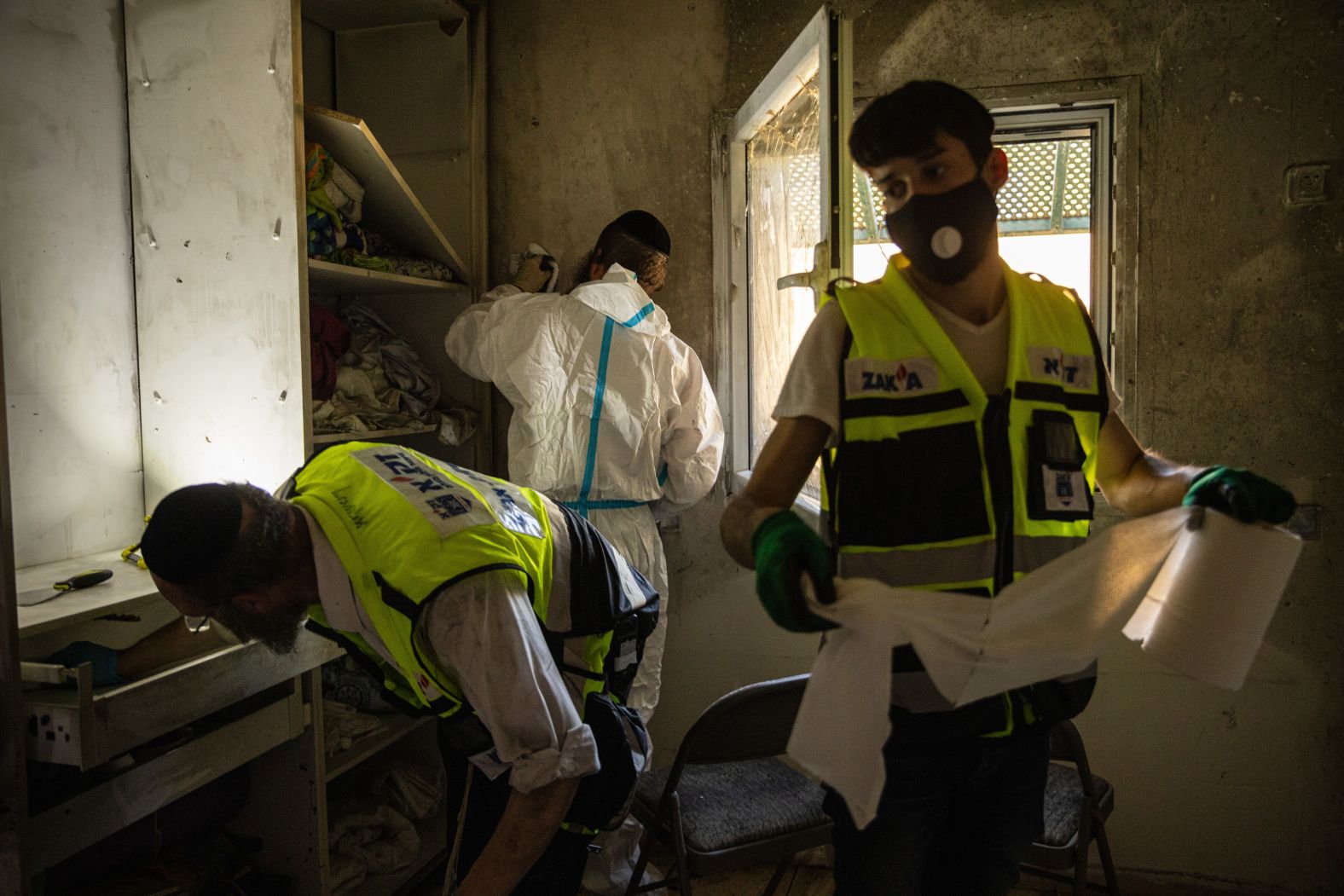 ZAKA volunteers clean a bedroom inside a home heavily damaged during Hamas' October 7 attack in the Israeli kibbutz of Holit on Thursday, October 26. Volunteers with the organization respond to emergencies and are responsible for helping identify and collect the remains of the deceased to be buried in accordance with Jewish religious law.