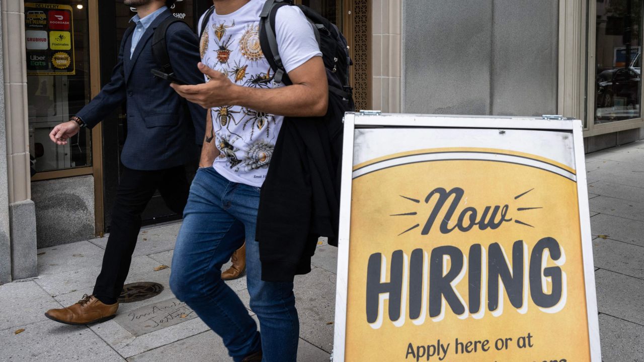 People walk past a restaurant, with a hiring sign outside, in Washington, DC, on October 5, 2023.  (Photo by ANDREW CABALLERO-REYNOLDS/AFP via Getty Images)