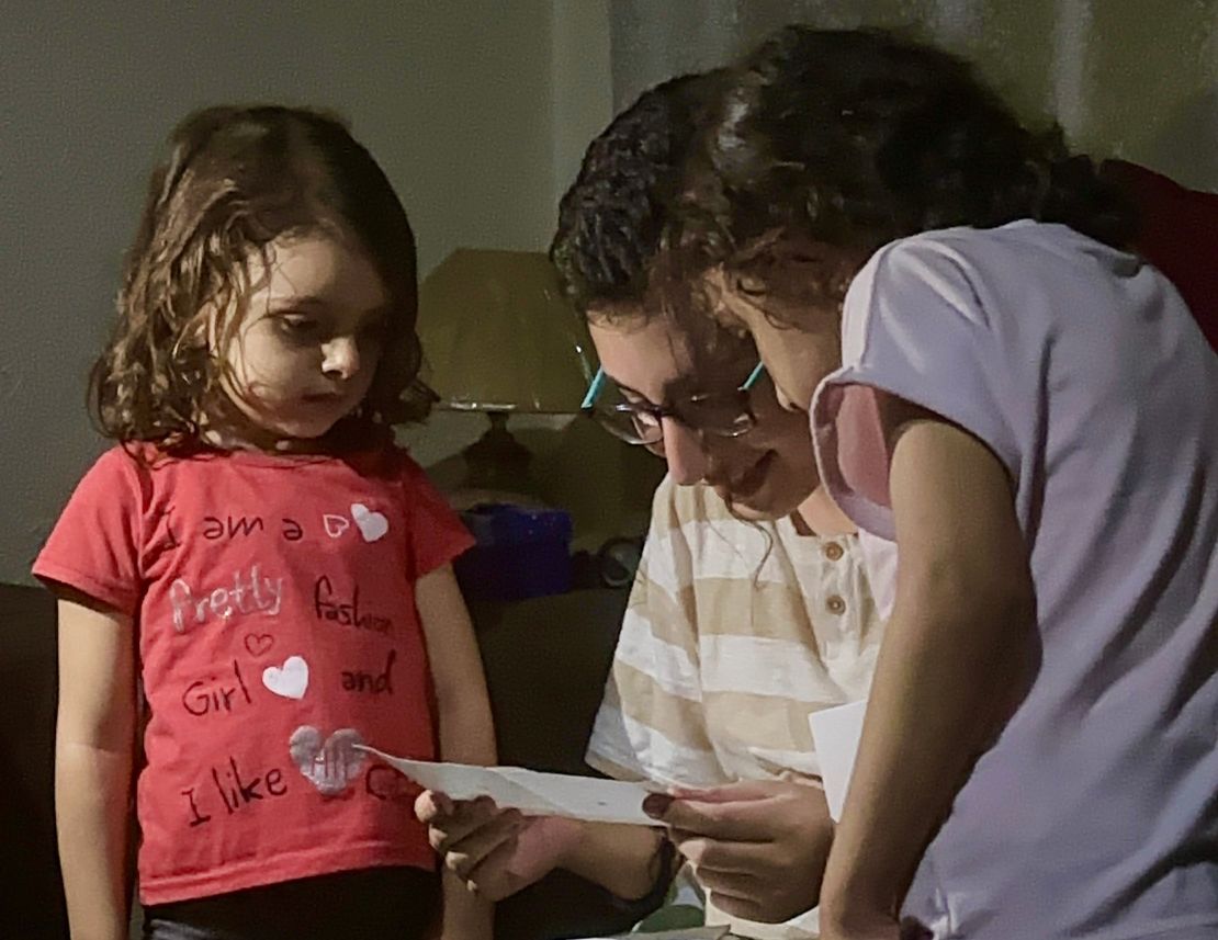 Gaza child Hashem reads a birthday card alongside his friends Tala and Sewar.